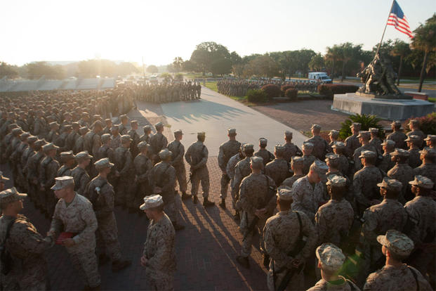 Drill instructors present their new Marines with Eagle, Globe and Anchors during the emblem ceremony Sept. 7, 2013, at the Iwo Jima flag raising statue on Parris Island, S.C. (Photo by Lance Cpl. MaryAnn Hill)