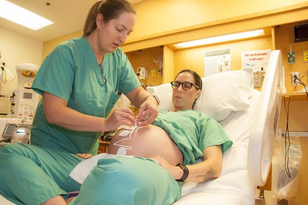 Maj. Lena Fabian (left), staff midwife at William Beaumont Army Medical Center, places a wireless monitoring system on Capt. Merry Fontenot, a staff midwife 36 weeks into her pregnancy on April 21, 2017. Starting in 2019, pregnancy will no longer be a qualifying life event to change Tricare plans. Marcy Sanchez/Army