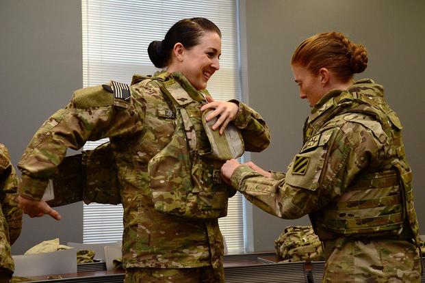 U.S. Army Pvt. 1st Class Cheryl Rogers grins as 2nd Lt. Chelsea Adams helps her into the new Generation III Female Improved Outer Tactical Vest at Fort Stewart, Ga., on Nov. 28, 2012. (U.S. Army photo by Cpl. Emily Knitter)