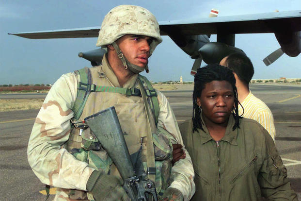 Lance Cpl. Curney Russell, from the 3rd Light Armored Reconnaissance Battalion, provides a steady arm for former prisoner of war Spc. Shoshana Johnson, with the 507th Maintenance Company, at Kuwait City, April 13, 2003, during Operation Iraqi Freedom. (U.S. Marine Corps/Michael Leitenberger)