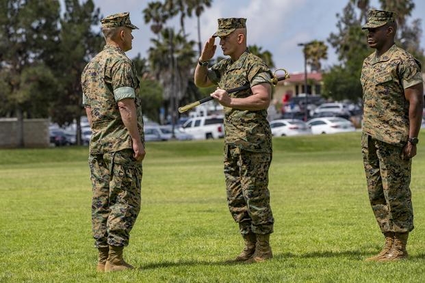 Sgt. Maj. Bradley Kasal, center, the outgoing I Marine Expeditionary Force sergeant major, relinquishes the sword of office during a relief and appointment ceremony on Camp Pendleton, Calif., on May 18, 2018. Sgt. Maj. James Porterfield, right, replaced Kasal as I MEF sergeant major. (U.S. Marine Corps photo by Lance Cpl. Clare Mcintire)