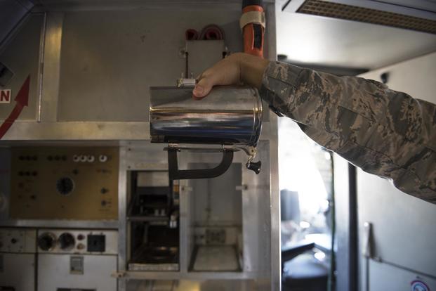 An Airman holds a hot cup inside a KC-10 Extender at Travis Air Force Base, Calif., June 21, 2018. The base is working on developing a new handle for the cup which could save the Air Force thousands. (U.S. Air Force/Tech. Sgt. James Hodgman)