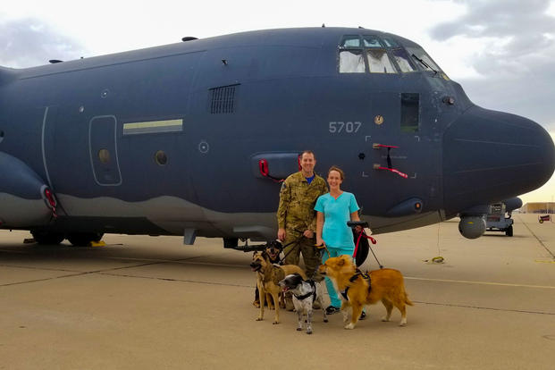U.S. Air Force Capt. Daniel Hale, 563rd Rescue Group officer in charge of plans and scheduling, and his wife Dr. Kristen Hale, veterinarian, pose in front of an HC-130J Combat King II with their rescue pets at Davis-Monthan Air Force Base, Arizona. (Courtesy of Kristen Hale)