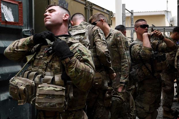 A U.S. Army Infantryman with the 10th Mountain Division assigned to the East African Response Force puts on his body armor in preparation for an emergency deployment exercise on Camp Lemonnier, Djibouti, July 1, 2018. (U.S. Air Force/Senior Airman Haley D. Phillips)