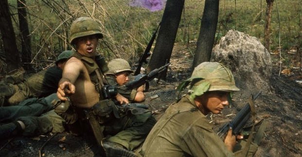 A U.S. soldier turns to give instructions as firing continues in front of him during Operation Byrd.