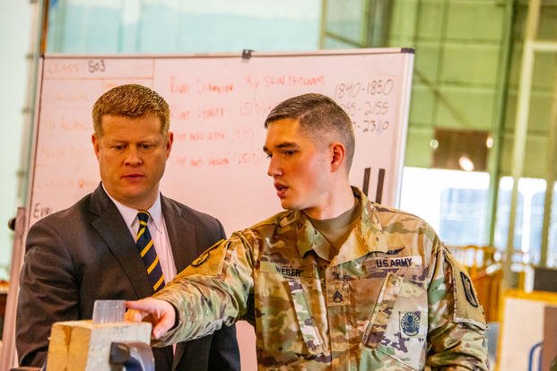 Under Secretary of the Army Ryan McCarthy looks at aviation maintenance equipment as Staff Sgt. Galen Weber, instructor, 128th Aviation Brigade, explains a training exhibit during a tour of the Advanced Individual Training aviation structures hanger, at Fort Eustis, Va., Feb. 22, 2019. (U.S. Army photo/George Prince)