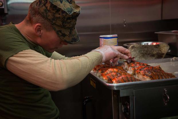 Cpl. Christian Harry with 2nd Marine Logistics Group-Forward checks the internal temperature of cooked lobsters for the 243rd Marine Corps birthday celebration at a Marine Corps Prepositioning Program-Norway location on Nov. 10, 2018. (U.S. Marine Corps photo by Sgt. Bethanie C. Sahms)