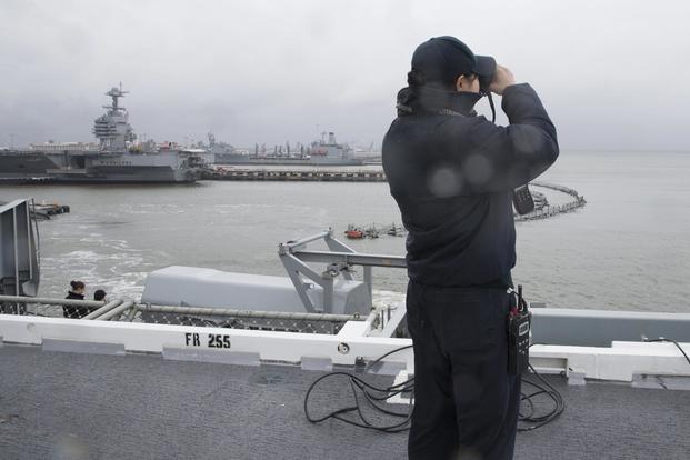 Lt. j.g. Riza Suriben looks out as the Nimitz-class aircraft carrier USS Abraham Lincoln (CVN 72) pulls out of Naval Station Norfolk. (U.S. Navy/Mass Communication Specialist 3rd Class Darion Chanelle Triplett)