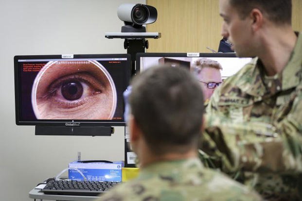 In a demonstration of the Telehealth process at Fort Campbell's Blanchfield Army Community Hospital, clinical staff nurse Lt. Maxx P. Mamula examines mock patient Master Sgt. Jason H. Alexander using a digital external ocular camera. (U.S. Army photo/Gigail Cureton)