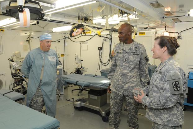 Col. Judith A. Bock and Command Sgt. Maj. Garfield Skyers talk to Cpt. Patrick Givens in the operating room of an 84 bed combat support hospital during U.S. Army Pacific's Medical Exercise Aug. 23, 2012. (U.S. Army/Sgt. 1st Class Rodney Jackson)
