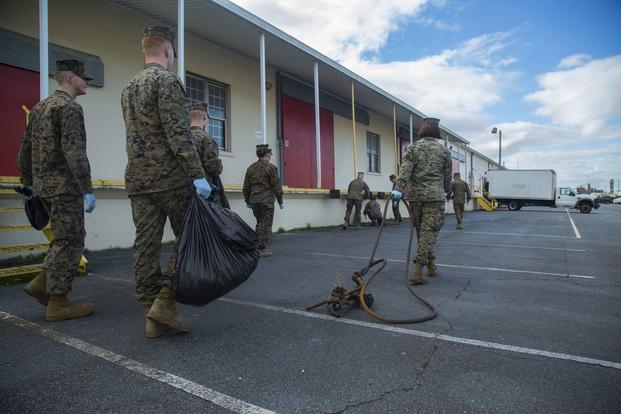U.S. Marines with Headquarters and Support Battalion, Marine Corps Installation East, pick up trash in a parking lot at Camp Lejeune, N.C., on Jan. 12, 2017. (U.S. Marine Corps photo by Lance Cpl. Austin Livingston)
