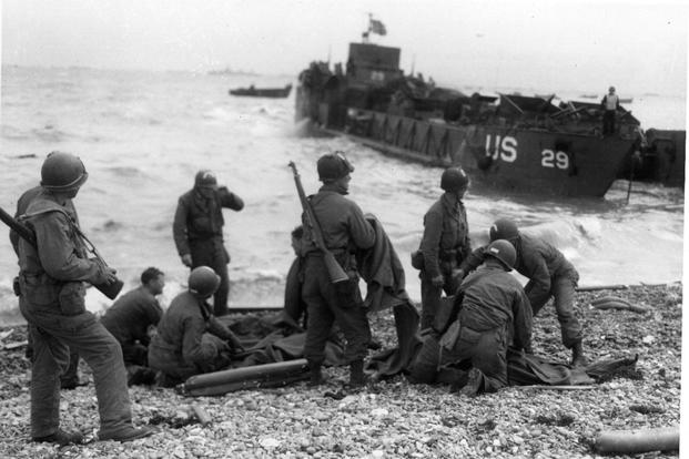 U.S. Army troops administer first aid to the survivors of sunken landing craft, on D-Day, June 6, 1944. (Photo from the Army Signal Corps Collection in the U.S. National Archives)