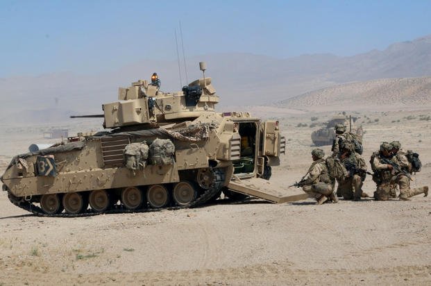 Infantrymen from the 3rd Infantry Division’s 2nd Armored Brigade Combat Team prepare to move into the attack against a fictional town of Razish at the National Training Center at Fort Irwin, California. The flashing amber light on top of the Bradley fighting vehicle indicates that the vehicle has been knocked out by enemy fire. (Matthew Cox/Staff)
