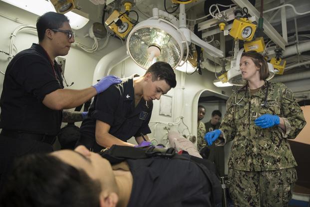 Hospital Corpsman 3rd Class Malachi Henderson reports the status of a simulated patient to Lieutenant Elizabeth Cooper while Hospital Corpsman 3rd Class Daniel Campoblanco records the injuries during a mass casualty drill aboard the USS Bataan. (U.S. Navy/Mass Communication Specialist Seaman Apprentice Levi Decker)