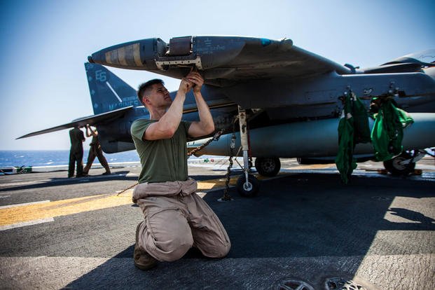 U.S. Marine Corps Sgt. Johnathan Davis, an AV-8B Harrier airframe mechanic assigned to Marine Medium Tiltrotor Squadron (VMM) 266 (Reinforced), 26th Marine Expeditionary Unit (MEU), performs general maintenance on his aircraft on the flight deck of the USS Kearsarge (LHD 3), at sea, July 20, 2013. (U.S. Marine Corps photo/Christopher Q. Stone)