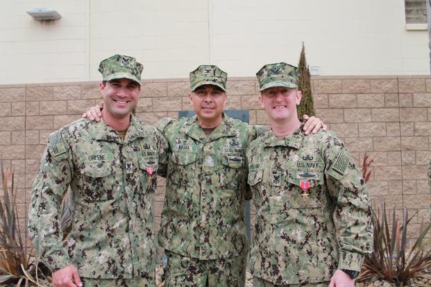 Capt. Oscar Rojas poses with Explosive Ordnance Disposal Technician First Class Petty Officer Travis Holland and Explosive Ordnance Disposal Technician First Class Petty Officer Christopher Greene during a bronze star ceremony, June 27, 2019 on Naval Outlying Landing Field Imperial Beach. (U.S. Navy/Lt. Kara Handley)