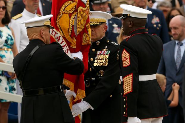 General Robert B. Neller, 37th Commandant of the Marine Corps, passes the Marine Corps Battle Color to Gen. David H. Berger, 38th Commandant of the Marine Corps, during a passage of command ceremony at Marine Barracks Washington, D.C., July 11, 2019. (U.S. Marine Corps/Pfc. Allen Sanders)