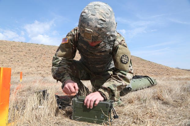 A soldier finishes putting a battery in a radio to call in a 9-Line during the Army's Best Warrior Competition. (Garrett Bradley/U.S. Army)