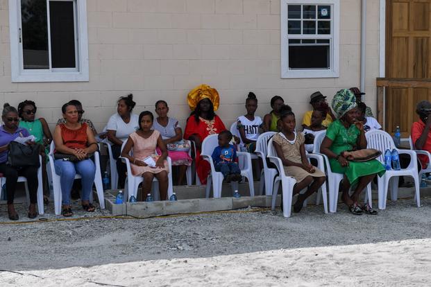Guyanese spectators sit at the handover ceremony for the village of Yarrowkabra community center during New Horizons exercise 2019 in the village of Yarrowkabra in Guyana, Aug. 5, 2019. The New Horizons exercise 2019 provides U.S. military members an opportunity to train for an overseas deployment and the logistical requirements it entails. The exercise promotes bilateral cooperation by providing opportunities for U.S. and partner nation military engineers, medical personnel and support staff to work and tr