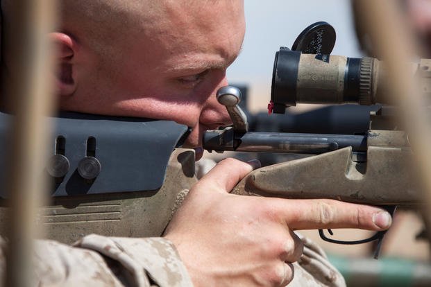 A Marine shoots a rifle. 
