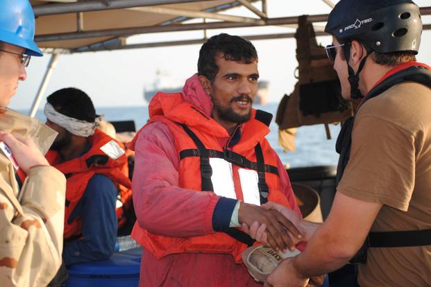 An Iranian mariner greets a U.S. Coast Guardsmen after being rescued.