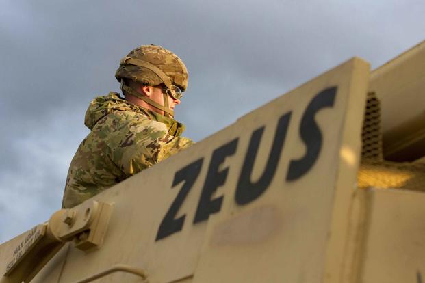 A soldier with 1st Armored Brigade Combat Team, 1st Infantry Division, sits atop a staged vehicle at the port of Bremerhaven, Germany, on Oct. 18, 2019. (U.S. Army photo by Sgt. Thomas Mort)