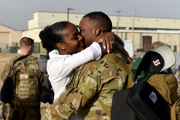 Airman hugs his spouse after returning from a deployment