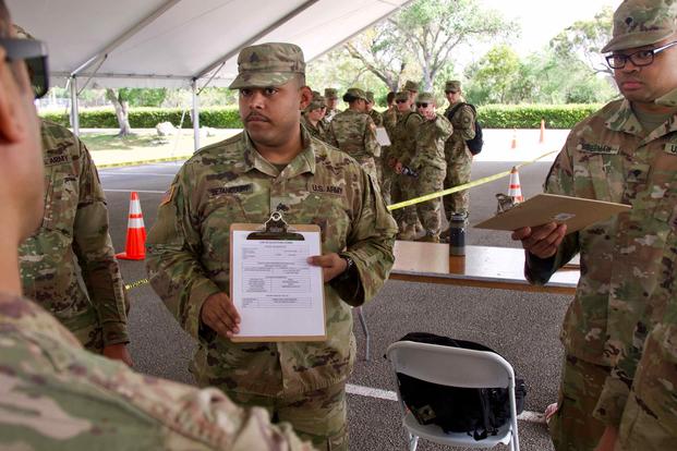 Florida National Guard Sgt. Jeff Betancourt reviews the scripting process with medics at a COVID-19 testing site. 