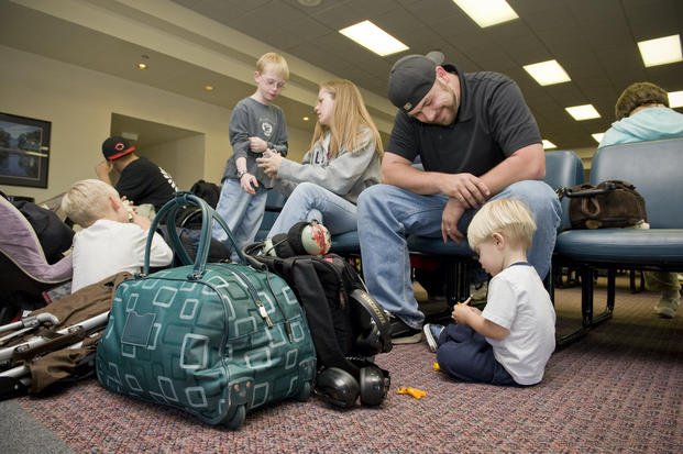 family sitting in airport waiting area