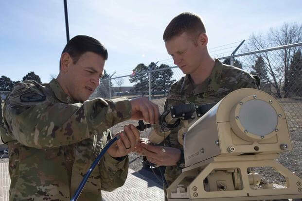 Soldiers from the 25th Space Range Squadron reinstall a K-under feed on a ground multi-band terminal antenna.