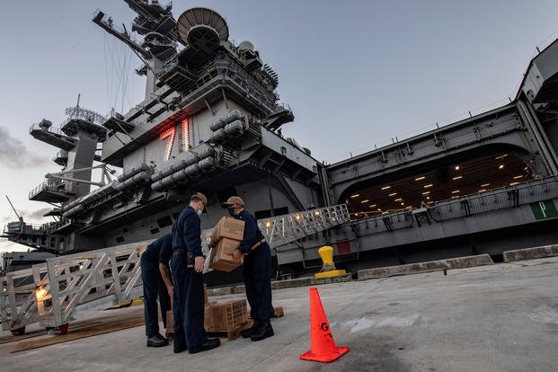 Sailors assigned to the aircraft carrier USS Theodore Roosevelt (CVN 71) move meals