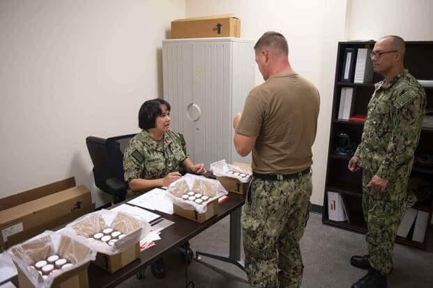 An operations specialist conducts a monthly urinalysis test of assigned Reserve Sailors