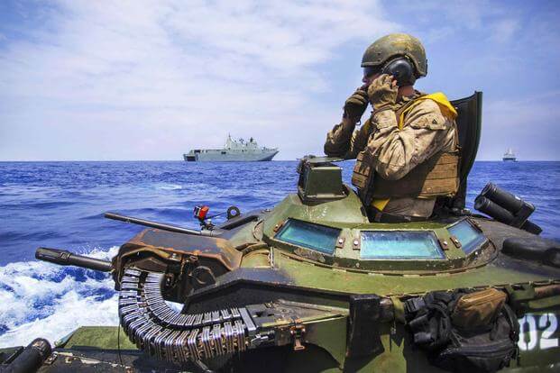 A U.S. Marine communicates with other assault amphibious vehicles.