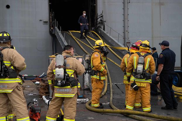 Sailors firefighters prepare to relieve hose teams on board USS Bonhomme Richard.