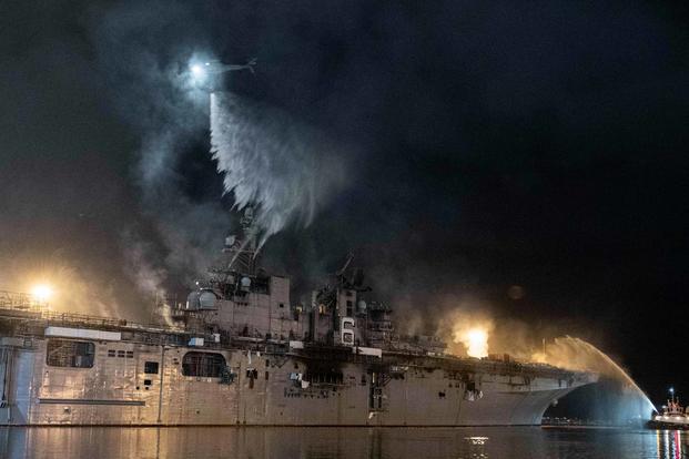 A helicopter combats a fire aboard the amphibious assault ship USS Bonhomme Richard.
