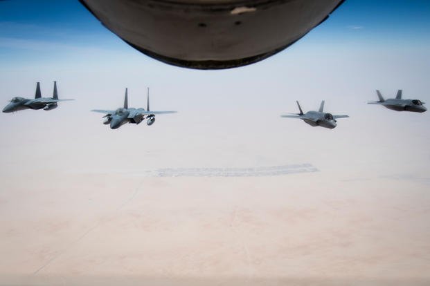 F-15C Eagles and F-35A Lightning IIs fly behind a U.S. Air Force KC-135 Stratotanker