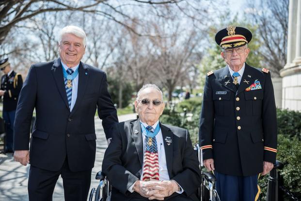 Three Medal of Honor recipients participate in a wreath-laying ceremony at the Tomb of the Unknown Soldier. 