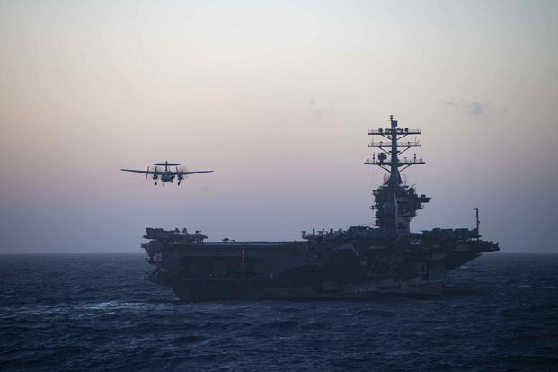 An E-2C Hawkeye prepares to land on the flight deck of the aircraft carrier Nimitz