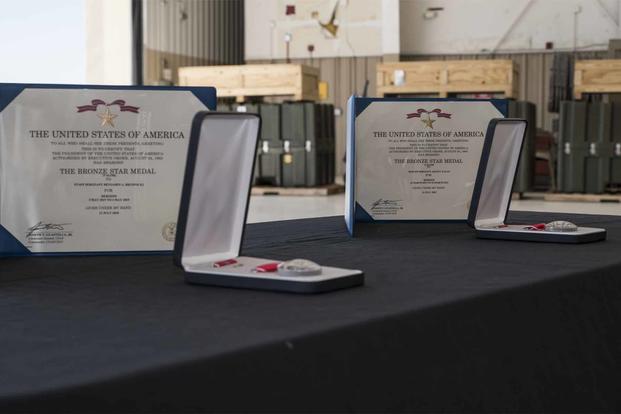Two Bronze Stars with valor sit on a table at Davis-Monthan Air Force Base.