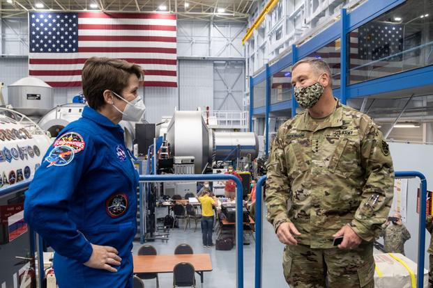 U.S. Army astronaut Lt. Col. Anne McClain talks with Gen. James Dickinson at Johnson Space Center.