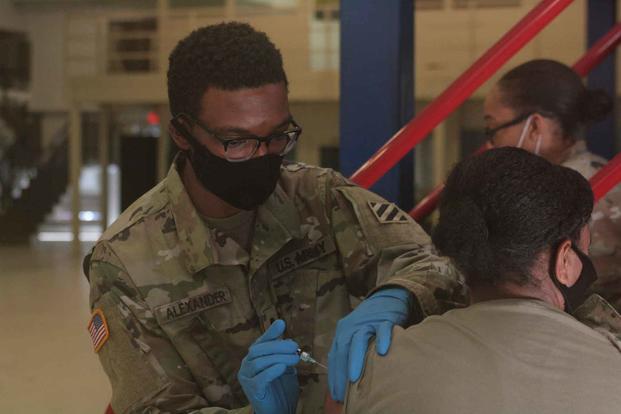 U.S. Army combat medic administers a flu vaccination.