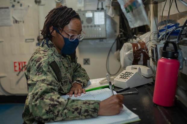 A Navy sailor writes in the deck log on the aircraft carrier USS George Washington.