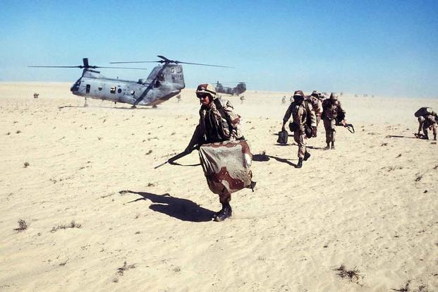 U.S. Marines disembark from a CH-46E Sea Knight helicopter Operation Desert Shield.