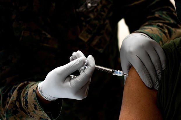 Navy corpsman administers a Marine with COVID-19 vaccine