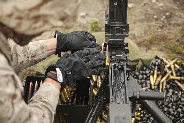 A Marine loads a .50-caliber machine gun.