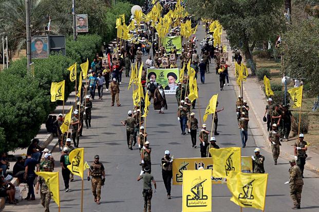 Iraqi Popular Mobilization Forces march in the streets in Iraq. 