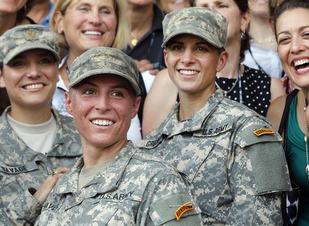 Female Army soldiers smile at the camera. 