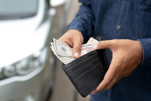 A man shows cash in his wallet