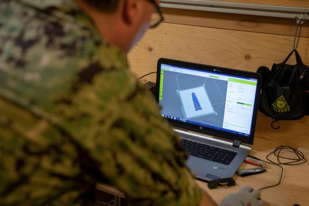 A Navy engineering duty officer uses 3D printing software.