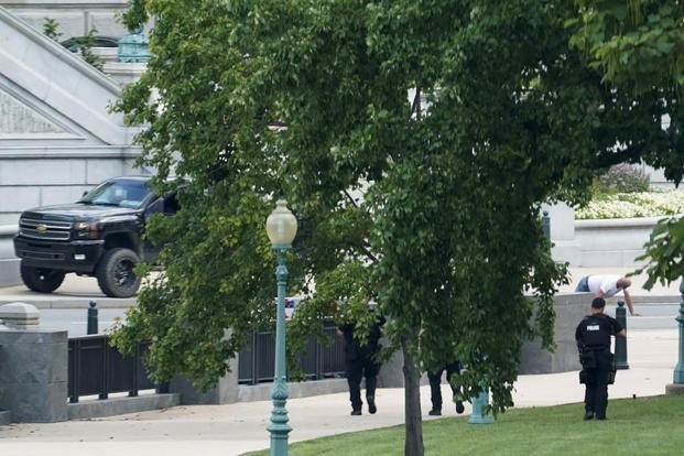 A person is apprehended on the sidewalk in front of the Library of Congress